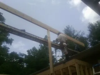 Carpenter setting a ridge beam over a new addition frame — Ice Dam Removal by Roofing Brothers in Thousand Oaks