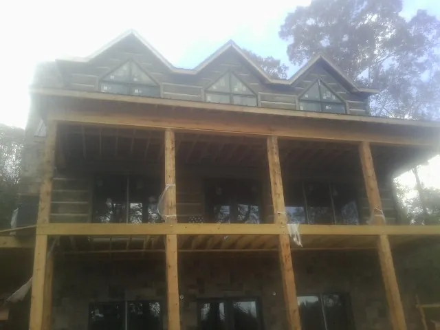Dormers and porch framing on a large log home under construction — Roof Coating work by our crew in Thousand Oaks