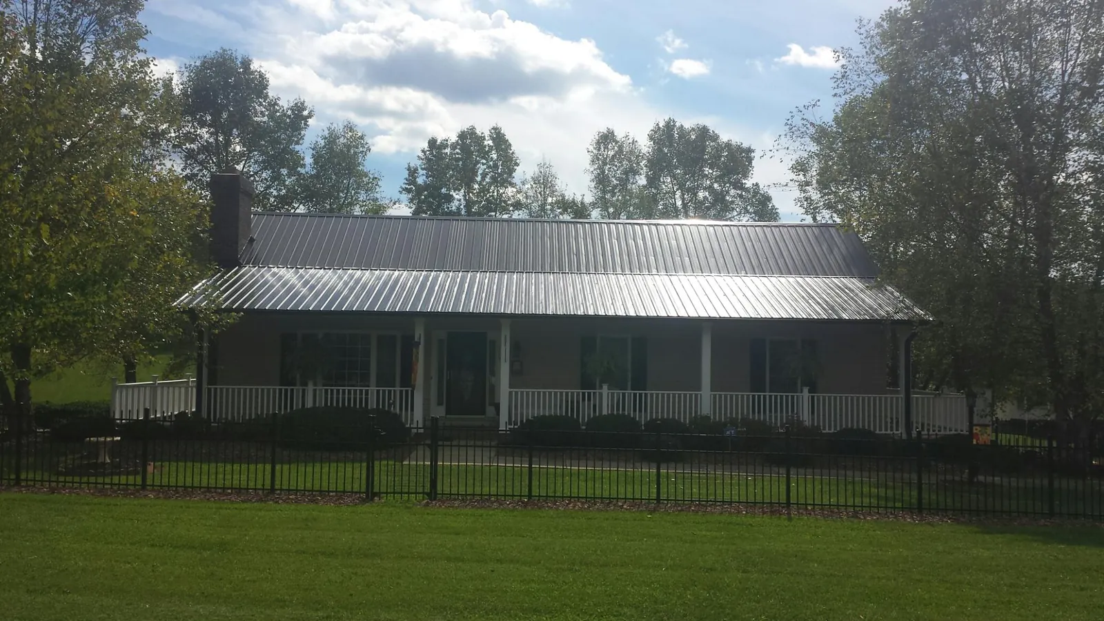 Gray metal roof on a brick ranch with a full width front porch — Gutter Guard Installation work by our crew in Thousand Oaks